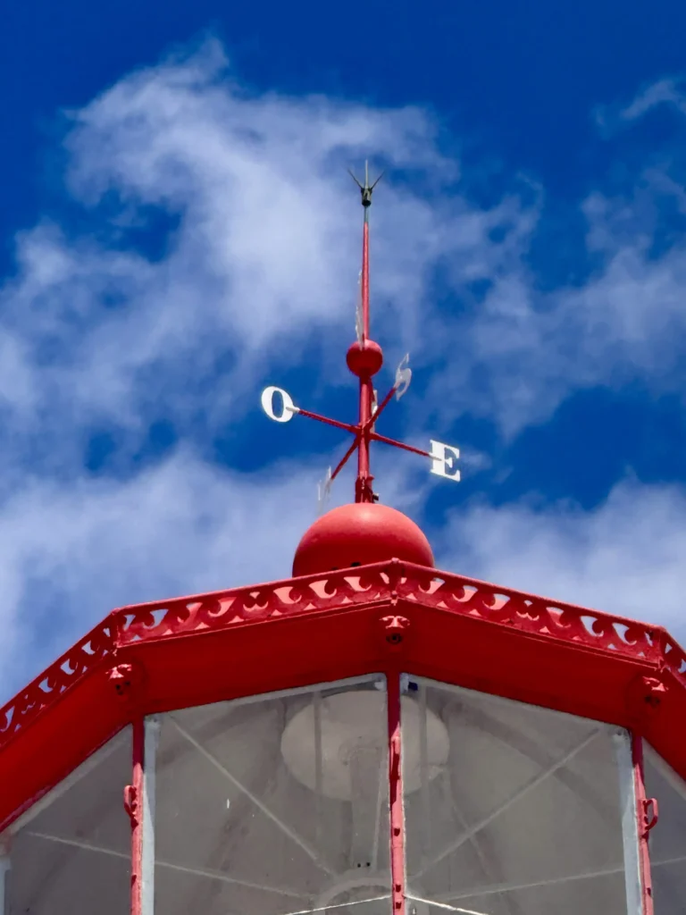 Lanterne rouge du phare de Bugio sur fond de ciel bleu.